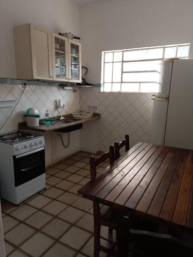 沃尔塔雷东达Apartamento MOBILIADO 2 QUARTOS的厨房配有桌子、炉灶和冰箱。