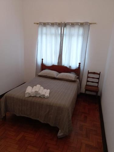 沃尔塔雷东达Apartamento MOBILIADO 2 QUARTOS的一间卧室配有一张床,并备有2个拖鞋