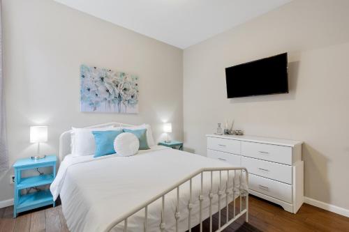圣路易斯Exquisitely Designed Townhome - JZ Vacation Rentals的卧室配有白色的床和电视