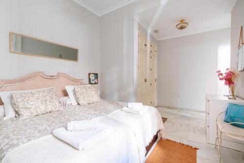塞维利亚San Lorenzo en Esencia的白色卧室配有一张大床和椅子