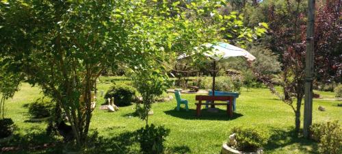 格拉玛多Cabanas Brocker的花园配有桌椅和遮阳伞。
