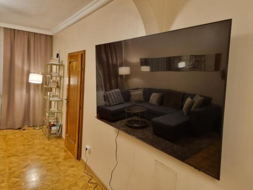维也纳Villa with private Sauna and Jacuzzi, 8 min from Schloss Schöbrunn的客厅配有沙发和墙上的电视
