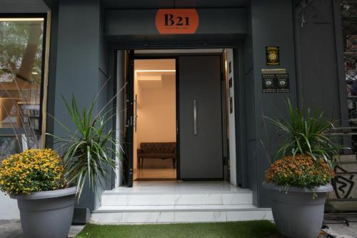 雅典B21Residence的两棵盆栽植物的建筑物的前门