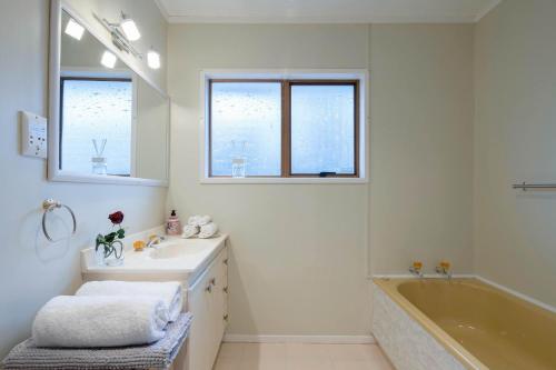 奥克兰The waterfront 361-Family retreat with Netflix Skysport Air conditioner in each bedroom的白色的浴室设有浴缸、水槽和浴缸。