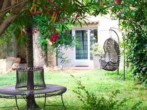 Pouzols克洛斯德拉库鲁比旅馆的花园设有两把椅子、一张桌子和秋千
