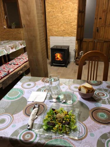 MontblanquetRefugi MARILLUNA的餐桌,餐桌上放着一盘食物,壁炉
