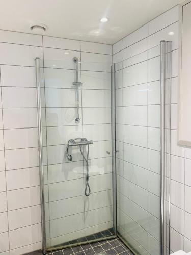 滕斯贝格Leilighet ved Slottsfjellet的浴室设有白色瓷砖墙壁和淋浴。