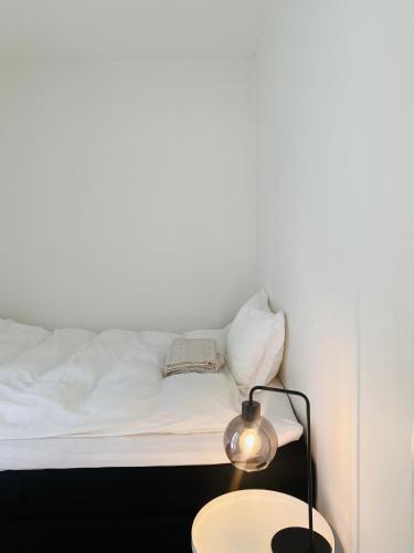 滕斯贝格Leilighet ved Slottsfjellet的一间卧室配有一张床和一张带台灯的桌子