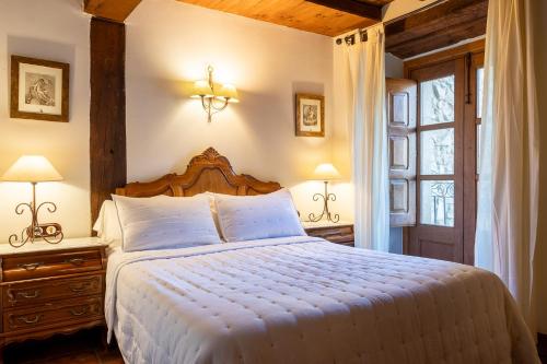 纳瓦孔塞霍拉富恩特德尔赫尔特乡村住宿加早餐旅馆的一间卧室配有一张床、两盏灯和一个窗户。