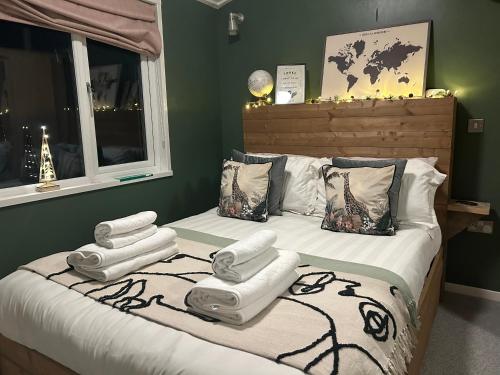 纽基Woodpecker Lodge的一间卧室配有一张床,上面有四条毛巾