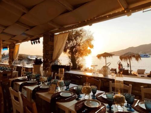 波西多尼亚Boutique ''Di Mare'' Hotel & Suites的一间设有桌椅并享有水景的餐厅