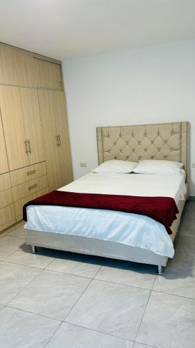 皮塔利托Apto con parqueadero Escalini Mansión Puerta del sol Pitalito的一间卧室配有一张带红色毯子的大床