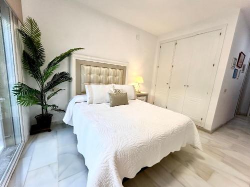 拉海瑞德拉Casa Caracol的卧室配有白色的床和盆栽植物