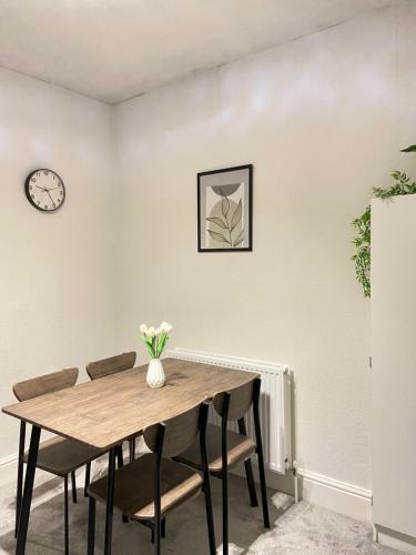 赫尔Kisobi Home Bedroom 2的餐桌、椅子和墙上的时钟