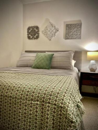 危地马拉Casa 96的一间卧室配有一张带绿色枕头的大床