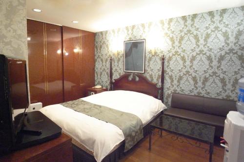 明石市ホテル タイムレス 明石 男塾ホテルグループ的一间卧室配有一张床和淋浴