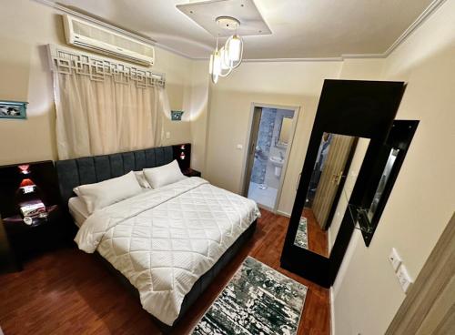 开罗The Arabella House - New Cairo的一间卧室配有一张带白色床单的床和一扇窗户。
