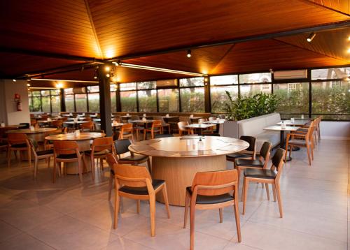 圣保罗Flat Tatuapé Sua Casa Your Home的餐厅设有桌椅和窗户。