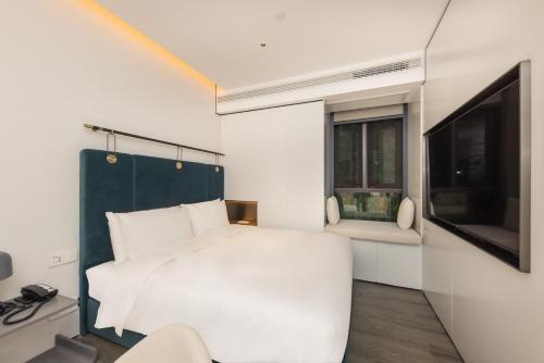 上海上海外滩盎格酒店的卧室配有白色的床和电视