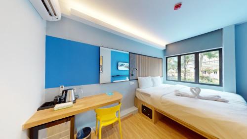 八打灵再也Blue Lagoon At Bandar Sunway的一间卧室配有书桌、一张床、一张桌子和椅子