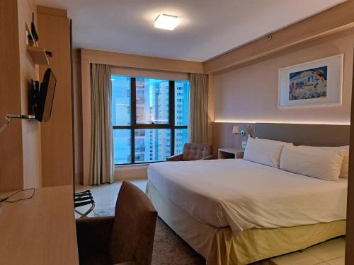 巴西利亚BSB STAY Flats particulares - CULLINAN的酒店客房设有一张床和一个大窗户