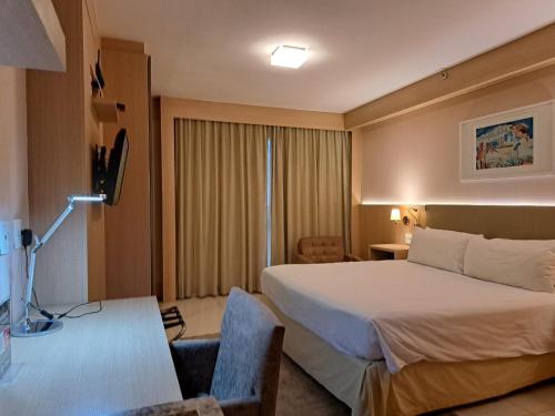 巴西利亚BSB STAY Flats particulares - CULLINAN的配有一张床和一张书桌的酒店客房