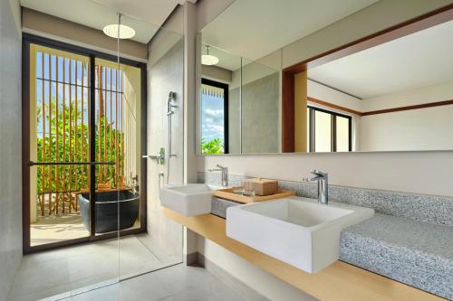 TanjungbingaSheraton Belitung Resort的浴室设有2个水槽和镜子