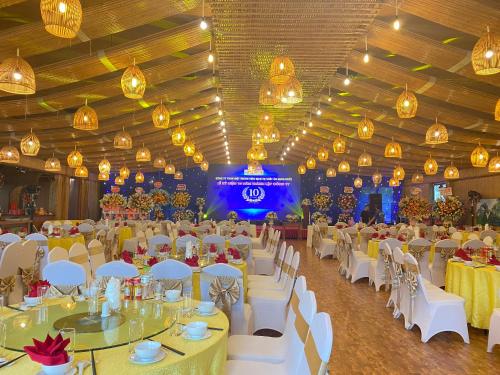 宁平Thung Nham Resort的宴会厅配有白色的桌椅和灯