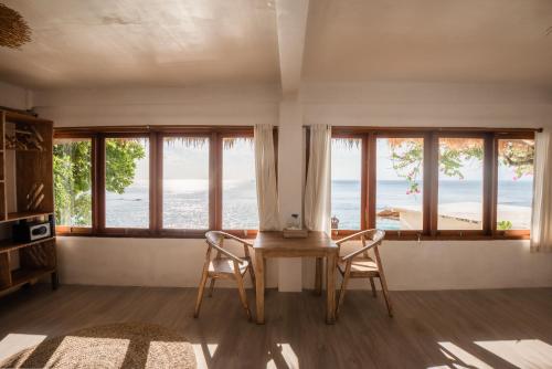 乌鲁瓦图岩礁旅馆的客厅设有窗户和桌椅