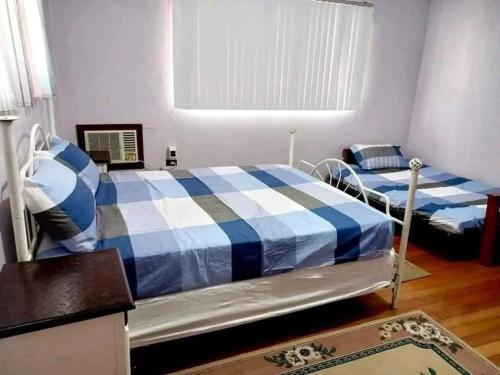 Mauban3B Cozy home的一间卧室设有两张床和窗户。