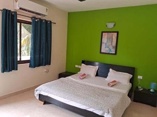 瓦尔恰Coconut Grove Holiday Apartment的一间带绿色墙壁的卧室和一张带两张粉红色床垫的床