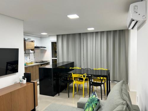 戈亚尼亚Apartamento perfeito em bairro nobre por insta @thiagojacomo的一间用餐室,配有一张黑桌子和黄色椅子
