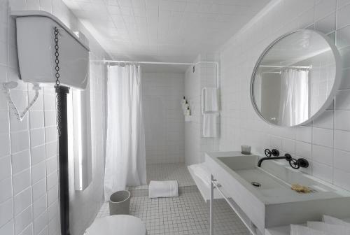 墨西哥城卡洛塔酒店的白色的浴室设有水槽和镜子