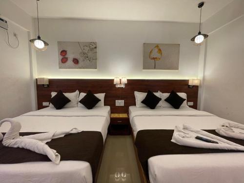 巴加Yellow Sky的酒店客房,设有三张床和三盏灯