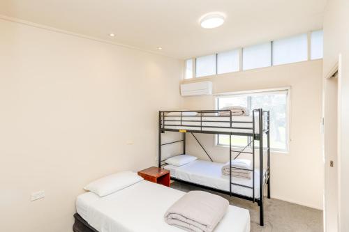 莱克斯恩特伦斯NRMA东海滩度假酒店的一间卧室设有两张双层床和一扇窗户。