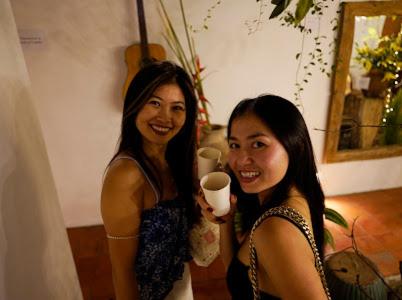 胡志明市Notre Maison 8 Saigon close Landmark 81 building的两个女人站在对方旁边拿着杯