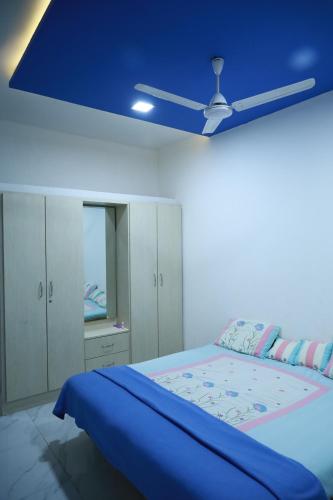普杰HOMESTAY ( EAGLE NEST )的一间卧室配有一张蓝色天花板的床
