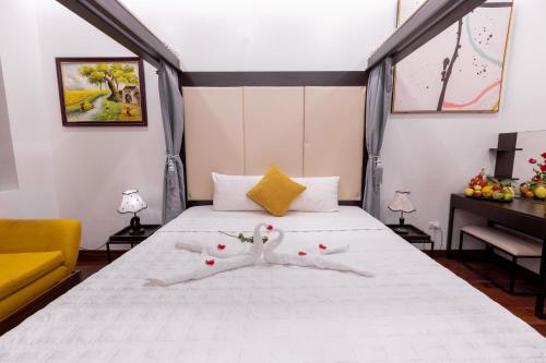 河内Hanoi Cozy Legend Hotel的一间卧室配有一张带白色床单和黄色沙发的床。