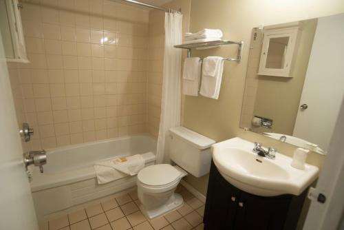 萨斯卡通Midtown Inn的浴室配有卫生间、盥洗盆和浴缸。