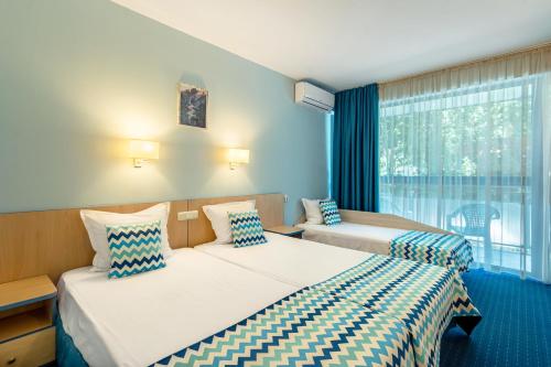 金沙BSA Holiday Park Hotel - All Inclusive的酒店客房设有两张床和窗户。