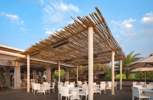 罗威那Lovina Beach Club & Resort的凉亭配有白色桌椅和遮阳伞