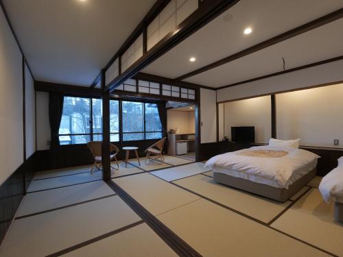 草津Kusatsu Onsen Kusatsu Hotel1913的一间设有床铺的卧室,位于带窗户的房间内