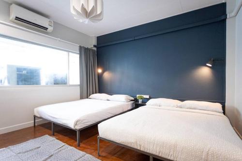 曼谷A2 Comfortable space wt Kitchen的蓝色墙壁客房的两张床