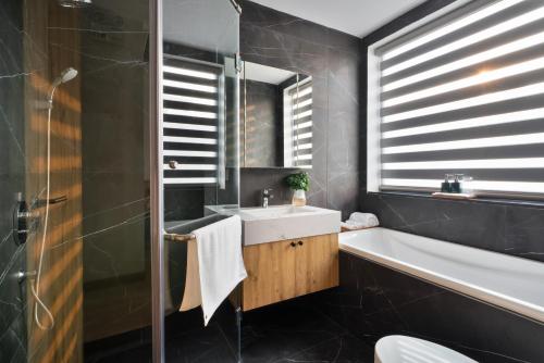 河内The Galaxy Home Doi Can Hotel and Apartment的浴室配有盥洗盆和浴缸。
