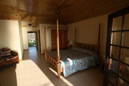 尼格瑞尔海市蜃楼旅馆的一间卧室设有一张床和木制天花板