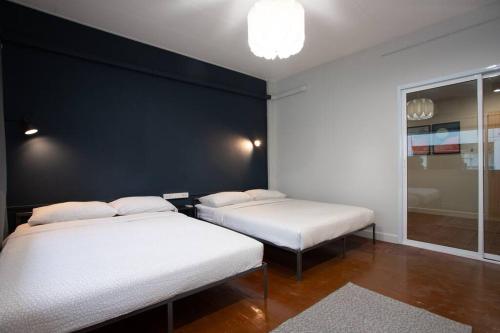 曼谷A3 Large Room, Full Facilities的一张黑墙客房内的两张床