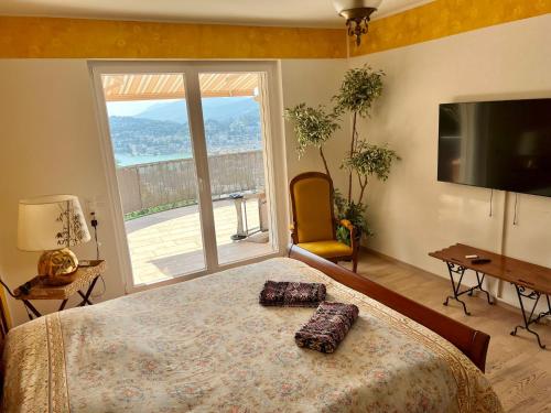 卢加诺阳光明媚的天堂公寓的一间卧室设有一张大床和一个大窗户