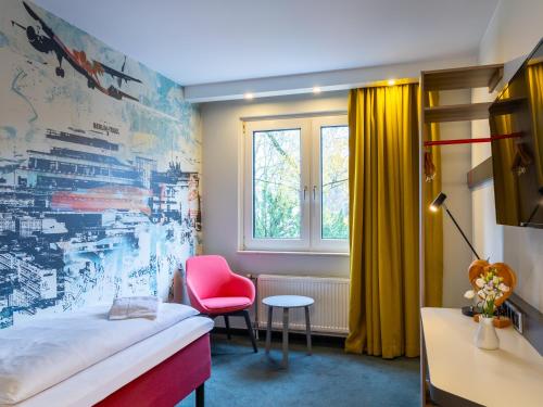 柏林Good Morning Berlin City West的客房设有床、椅子和窗户。