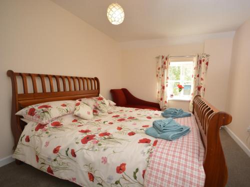马托克3 bed in Martock 51722的一间卧室配有一张带花卉床罩的床和窗户。
