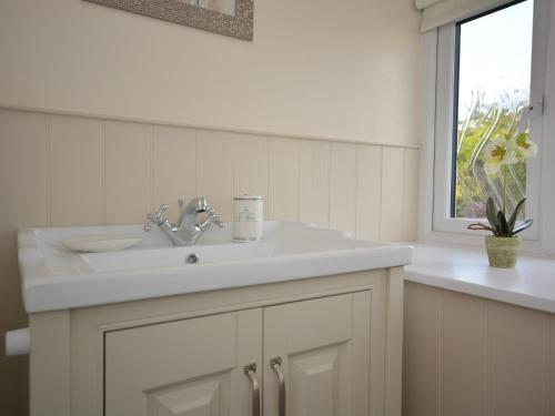 马托克3 bed in Martock 51722的白色的浴室设有水槽和窗户。